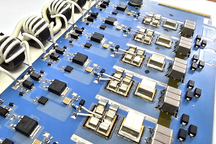 Bestücktes Hybrid-Leistungsmodul auf blauem Substrat mit Ringkern-Übertragern, Leistungshalbleitern und Metallclip-Kontaktierung